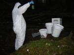 A contractor working with the federal Drug Enforcement Administration processes materials at a suspected meth lab site in Petersburg